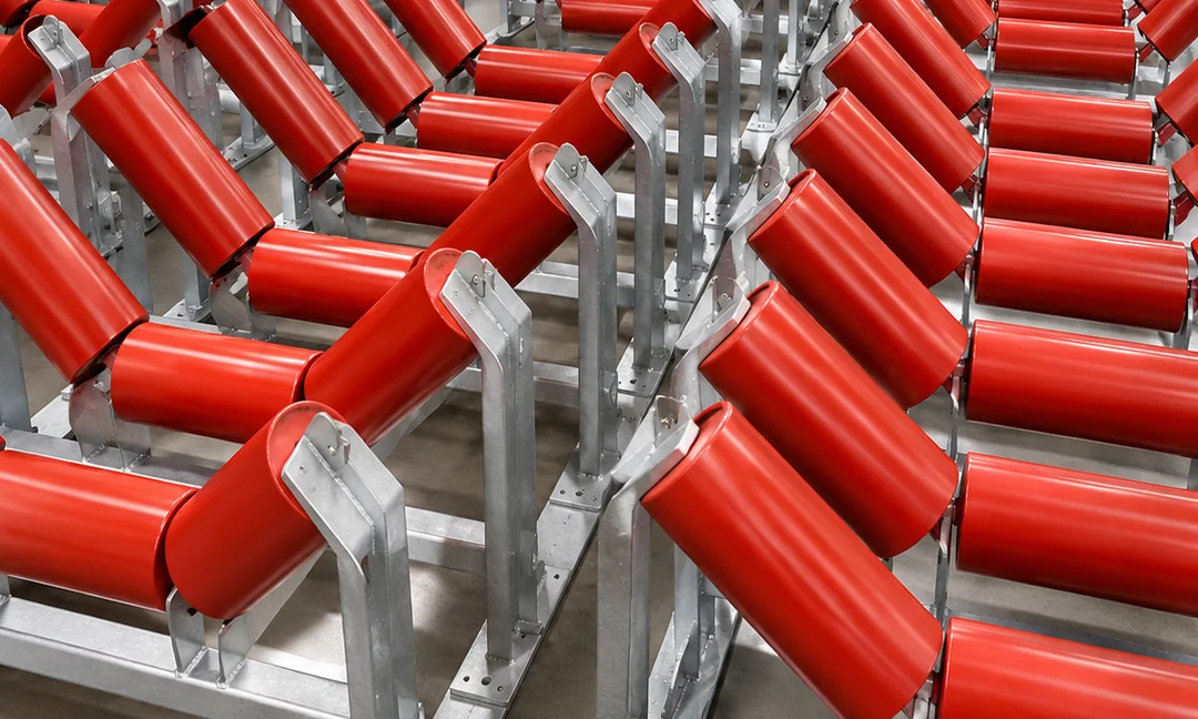 Rows of conveyor idler roller assemblies in a workshop