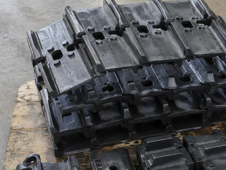 Steel track shoes arranged on a workshop pallet