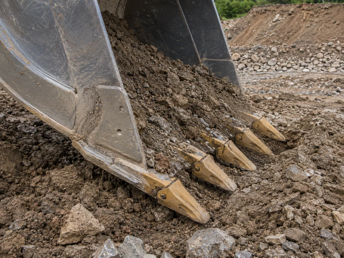 Excavator bucket teeth working in rocky ground