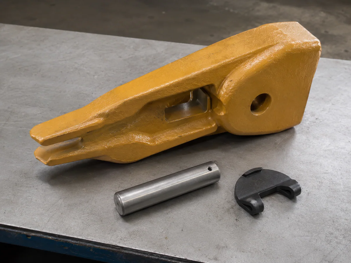 Bucket tooth adapter shown with its retaining pin and lock