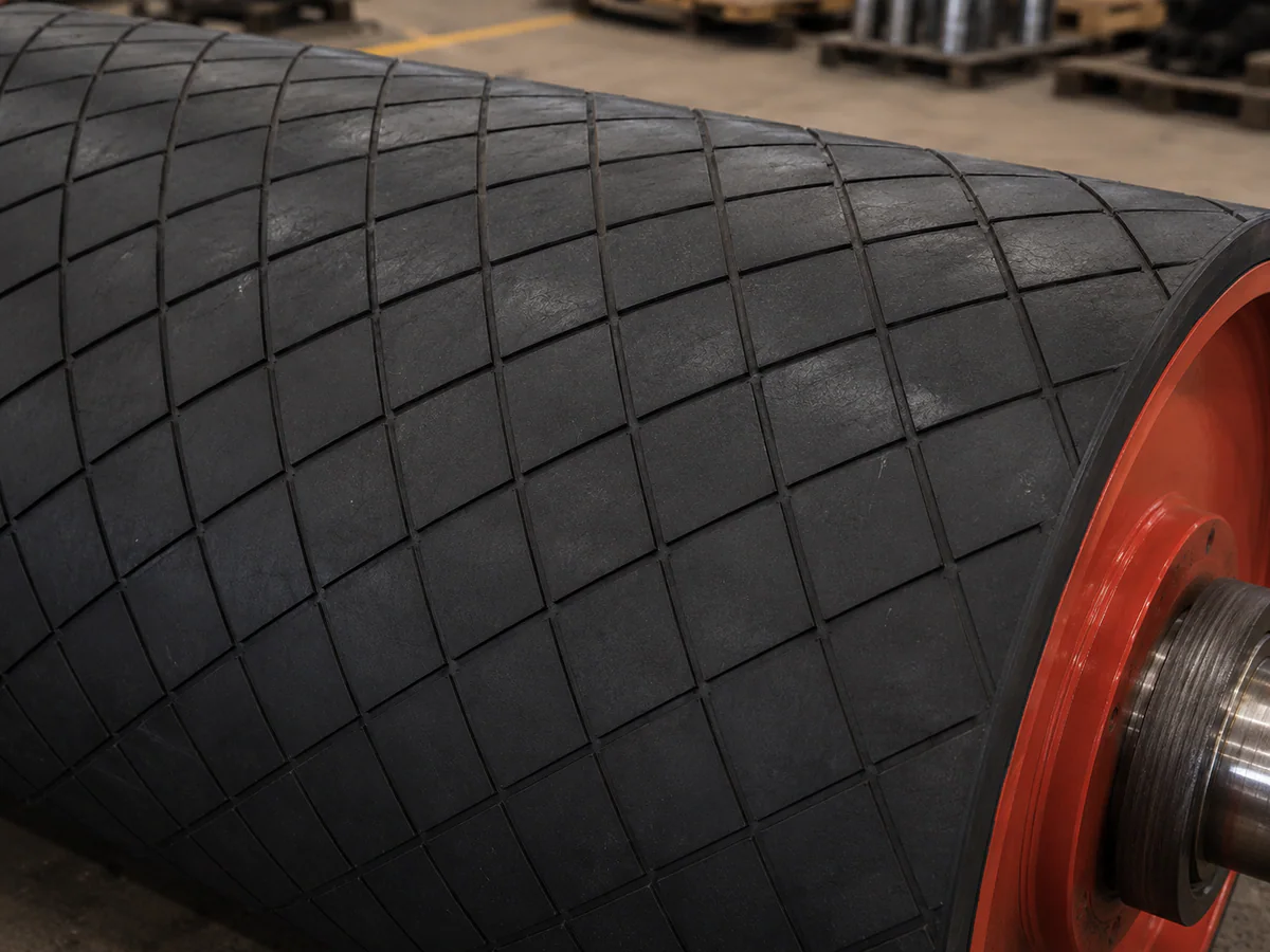 Close view of diamond-pattern rubber lagging on a conveyor pulley