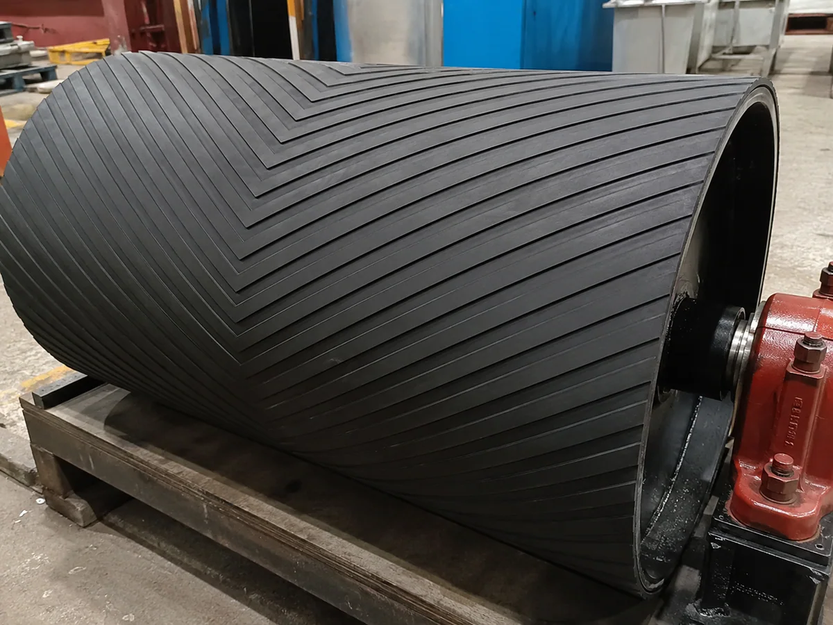 Conveyor pulley with herringbone-pattern rubber lagging