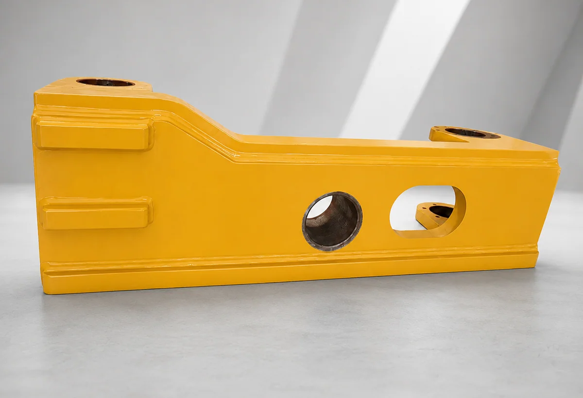 Yellow welded heavy-equipment frame component with machined interfaces